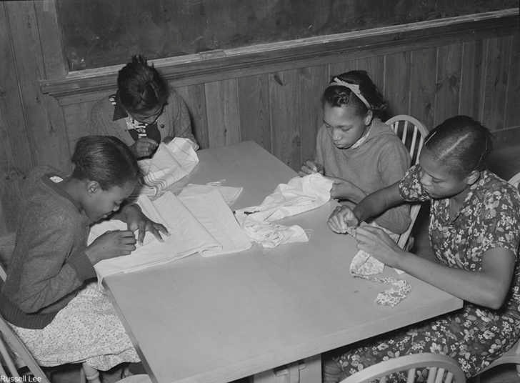 Girls in an Arkansas home ec class learning sewing skills. Via/ Library of Congress